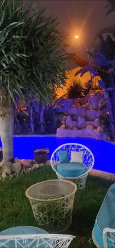 a group of chairs in a yard at night at Villa Magnifique M9 in Tunis