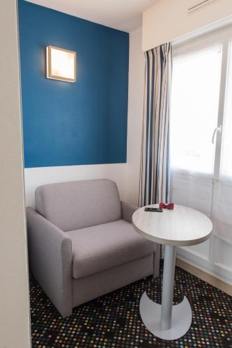 a living room with a couch and a table at ibis Styles St Gilles Croix de Vie centre-ville in Saint-Gilles-Croix-de-Vie