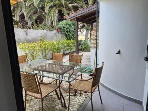 a glass table and chairs on a patio at Oceano Azul in Porto Santo