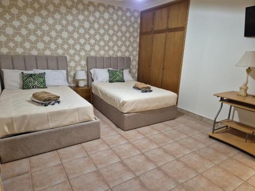 a hotel room with two beds and a table at Oceano Azul in Porto Santo