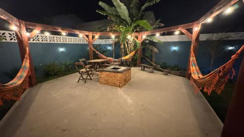 a patio with a table and chairs and lights at Casa Vila Say 04 quartos ar e Piscina Aquecida in São Francisco do Sul