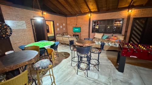 a living room with a table and some chairs at Casa Vila Say 04 quartos ar e Piscina Aquecida in São Francisco do Sul