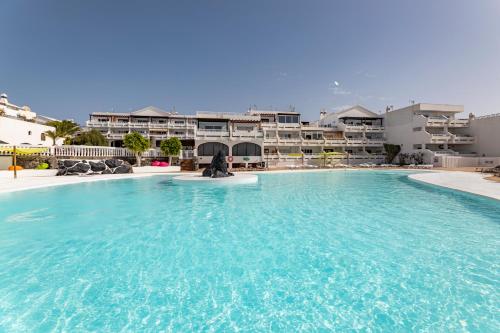a large swimming pool in front of a building at The Colors House, 646 y 524 - Private Apartments in Costa Teguise