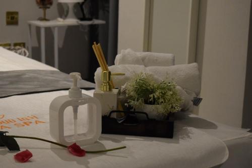 a bed with a glass bottle and flowers on a table at Saraya Corniche Hotel in Doha