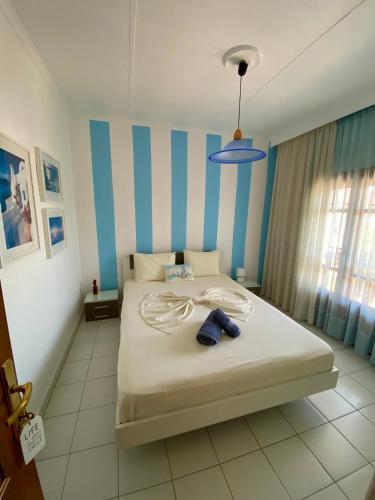 a bedroom with a bed with a blue and white stripes at Garden Summer House in Nea Kallikrateia