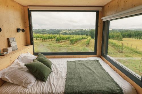 a bed in a room with a large window at Parcel Tiny House Couronneau près du Périgord in Ligueux