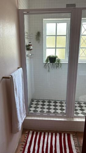 a bathroom with a shower with a checkered floor at Cardigan Cottage in McGregor