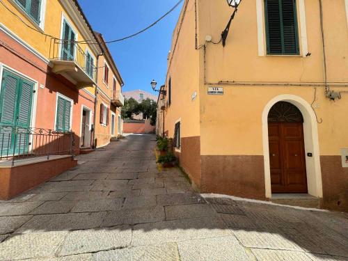 an empty alley with a building and a door at La Maddalena Tour Holiday Home - Residenza Alibertini in La Maddalena