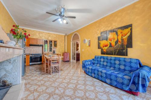 托雷拉皮罗La Corte del Geco的带蓝色沙发的客厅和厨房