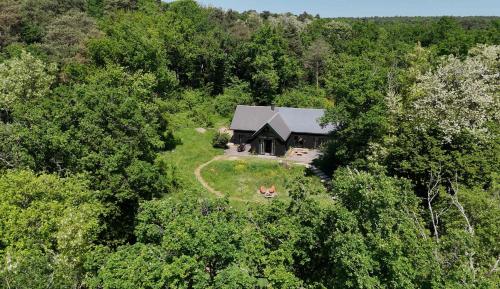 eine Luftaufnahme eines Hauses im Wald in der Unterkunft Maison de Reve avec Sauna en Pleine Foret in Le Vaudoué