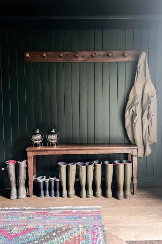 un mur végétal avec un banc en bois et quelques pots dans l'établissement Maison de Reve avec Sauna en Pleine Foret, à Le Vaudoué