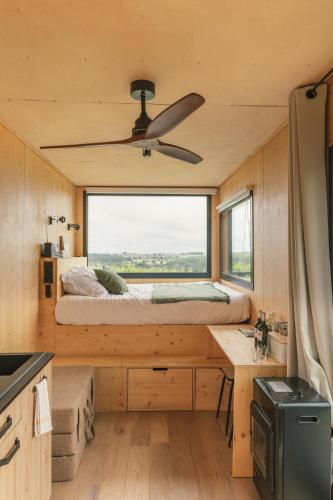 - une chambre dans une petite maison avec une grande fenêtre dans l'établissement Parcel Tiny House Couronneau près du Périgord, à Ligueux