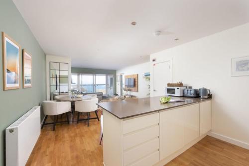 a kitchen with white cabinets and a counter top at 6 The Point, Newquay in Newquay