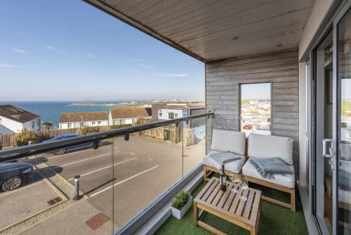a balcony with two chairs and a view of the ocean at 6 The Point, Newquay in Newquay