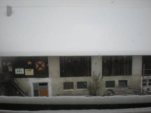 a building with snow on the windows of it at Erlebnishof Schiman in Kirchbach