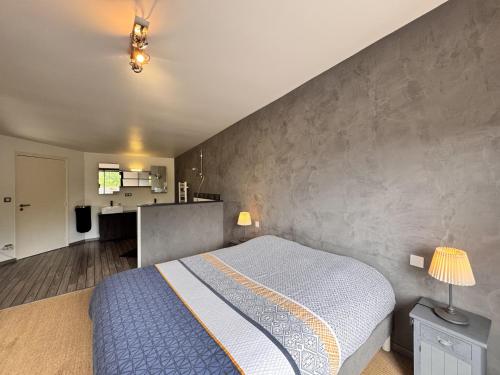 - une chambre avec un lit et un mur en béton dans l'établissement Le Paddock - Video Projecteur - Jardin - 6 pers, au Mans