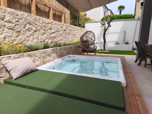 a hot tub on a patio with a chair at Sunset apartments Njivice in Njivice