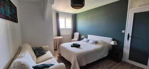 une petite chambre avec un lit et un canapé dans l'établissement Maison de charme à Grandcamp-Maisy avec vue sur la mer., à Grandcamp-Maisy