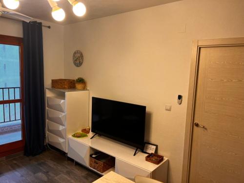 a living room with a flat screen tv on a white cabinet at Apartamento Luna Blanca, La Mata, 300 m from the sea and sandy beach plus swimming pool in La Mata