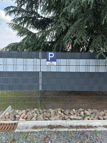 a parking sign in front of a fence at VillaKrocker - ElbeRadweg trifft WandKunstwerk in Burg bei Magdeburg