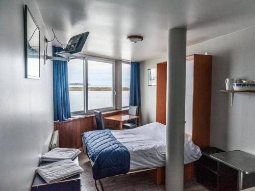 une chambre avec un lit, un bureau et une fenêtre dans l'établissement La presqu' île du Lenn face à la mer, à Louannec