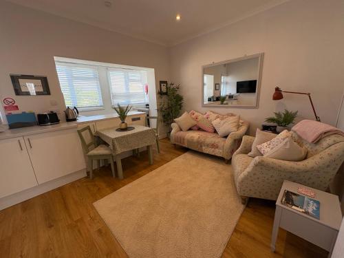 a living room with a couch and a table at Flat in the heart of Leigh on Sea less than 2 miles from the beach in Southend-on-Sea