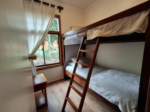 a bedroom with two bunk beds and a window at Cabanas Mapulauquen in Pucará
