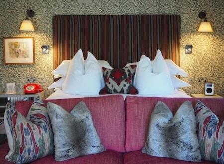 a bed with pillows on top of a pink couch at The Old Bridge in Huntingdon