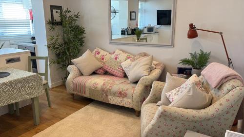 a living room with a couch and a mirror at Flat in the heart of Leigh on Sea less than 2 miles from the beach in Southend-on-Sea