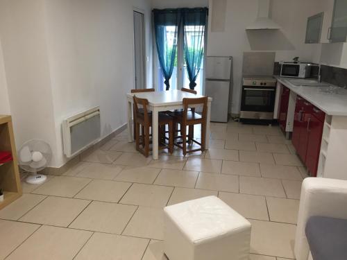 une cuisine avec une table et des chaises dans une pièce dans l'établissement Appartement proche du port, à Mèze