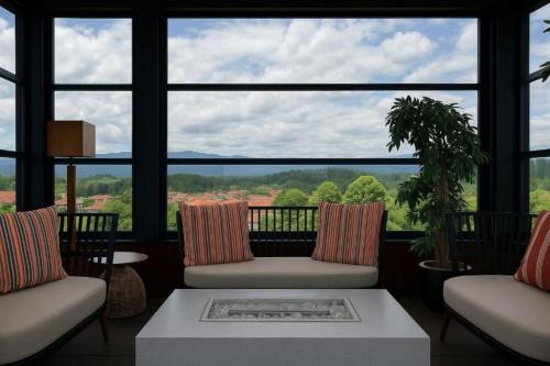a living room with two chairs and a large window at Regnum Banya Thermal Hotel in Banya