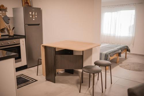 a kitchen with a wooden table and two stools at Odisea House 2 in Ljubaništa