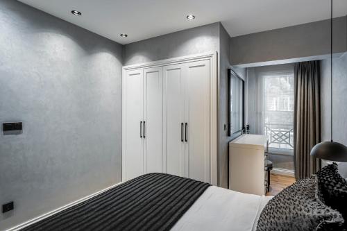 a bedroom with a bed and a white cabinet at Ena Boutique Hotel & Residences in Bodrum City
