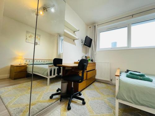 a bedroom with a desk and a bed at Spacious double bedroom with private bathroom ensuite and a new quality mattress in London Canary Wharf for short stay or long let near O2 and Excel Exhibition centre with easy reach from all airports in around London in London