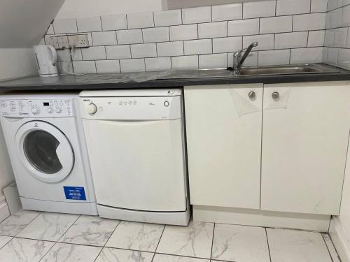 a kitchen with a washing machine and a sink at Spacious double bedroom with private bathroom ensuite and a new quality mattress in London Canary Wharf for short stay or long let near O2 and Excel Exhibition centre with easy reach from all airports in around London in London