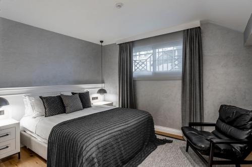 a bedroom with a bed and a chair and a window at Ena Boutique Hotel & Residences in Bodrum City