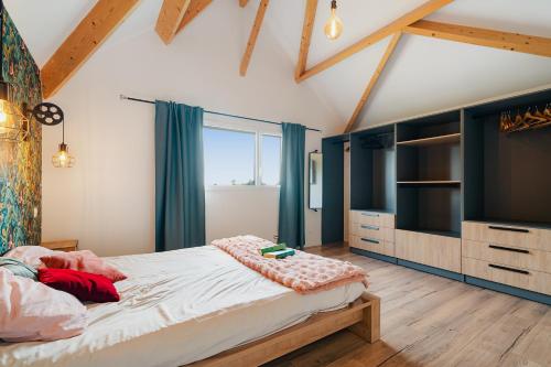 a bedroom with a large bed and a television at L'Escapade du Bord de Rance in Langrolay