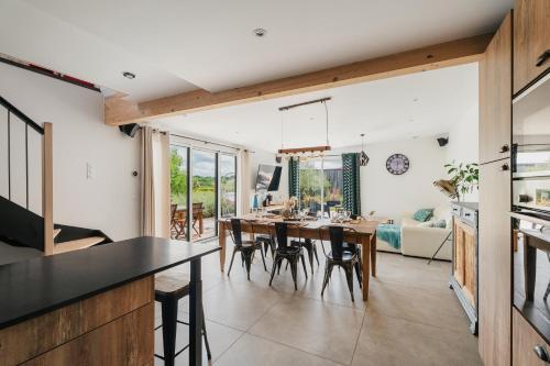 une cuisine et une salle à manger avec une table et des chaises dans l'établissement L'Escapade du Bord de Rance, à Langrolay