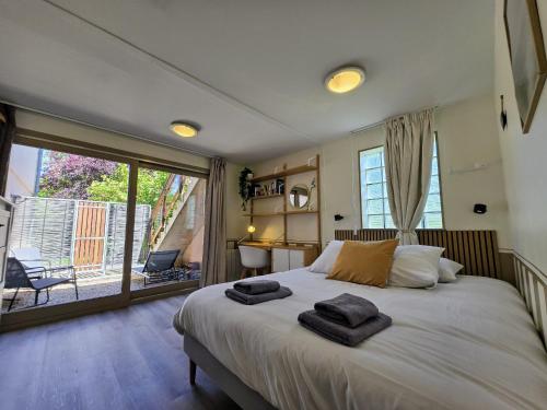 a bedroom with a bed with two towels on it at Appartement 2 chambres, Terrasses, Rez-de-Chaussée in Chablis