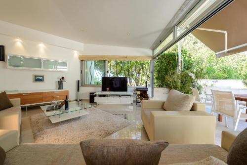 a living room with white furniture and a tv at Adriatic Resort Apartments in Dubrovnik