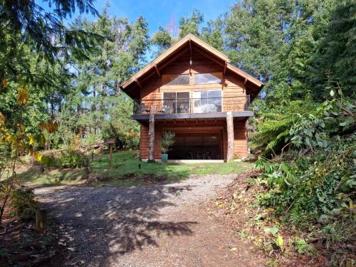 a log cabin in the woods with a balcony at Cabanas Mapulauquen in Pucará