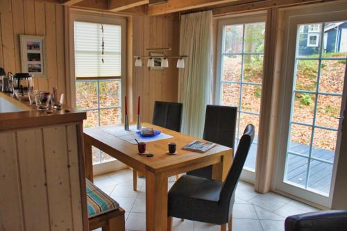 a kitchen with a wooden table and chairs and windows at Feenwald - Baabe in Baabe