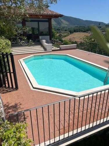 a swimming pool on a brick patio with a fence at Agriturismo Colle Sant Angelo in Serrone