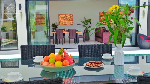 a glass table with a bowl of fruit on it at Santi Tara Villas in Amphoe Koh Samui