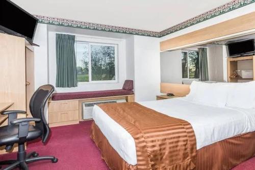 a bedroom with a bed and a desk and a chair at Brush Inn and Suites in Brush