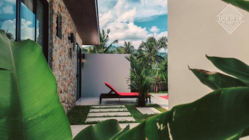 a red bench sitting on the side of a building at Santi Tara Villas in Amphoe Koh Samui