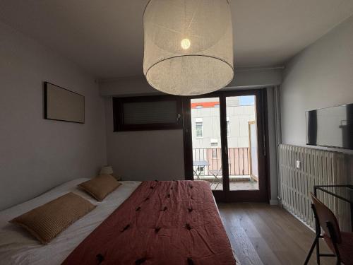 - une chambre avec un grand lit et un grand lustre dans l'établissement M74 Marquer joli studio centre ville, à Annemasse