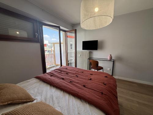 une chambre avec un grand lit avec une grande fenêtre dans l'établissement M74 Marquer joli studio centre ville, à Annemasse