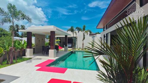 a villa with a swimming pool and a house at Santi Tara Villas in Amphoe Koh Samui