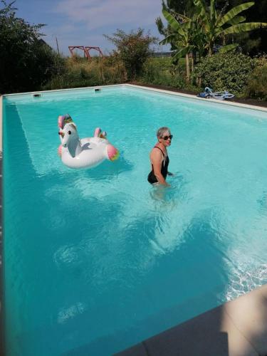 un homme dans une piscine avec deux bouées gonflables dans l'établissement Tente Safari équipée, à Sainte-Foy-la-Longue
